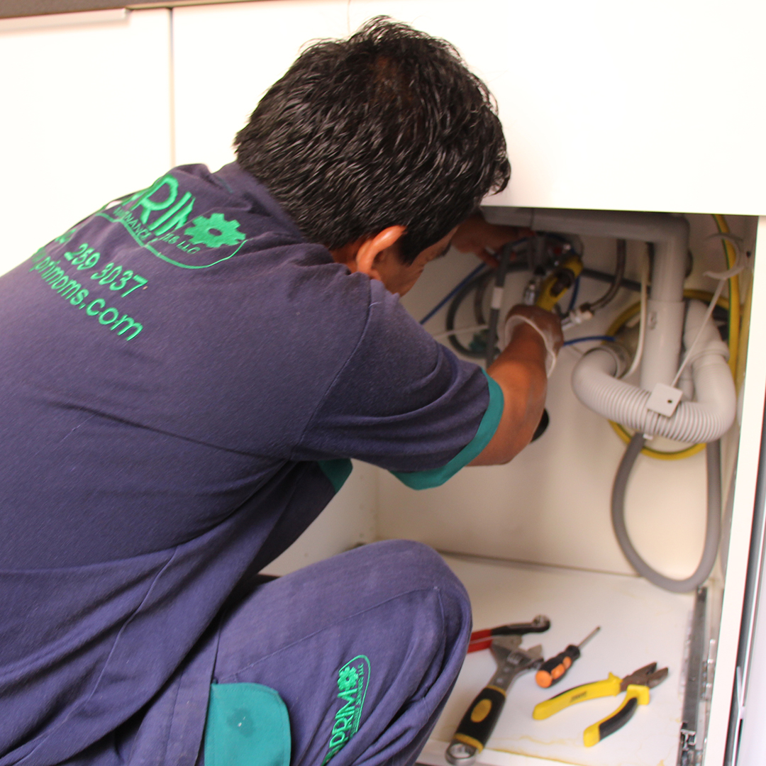 Primo technician carrying out plumbing work beneath a sink